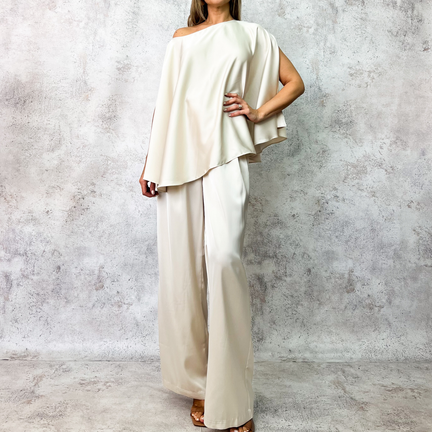 Conjunto beige con cinturón metálico.