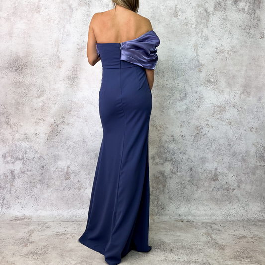 Vestido largo azul con escote drapeado y abertura.