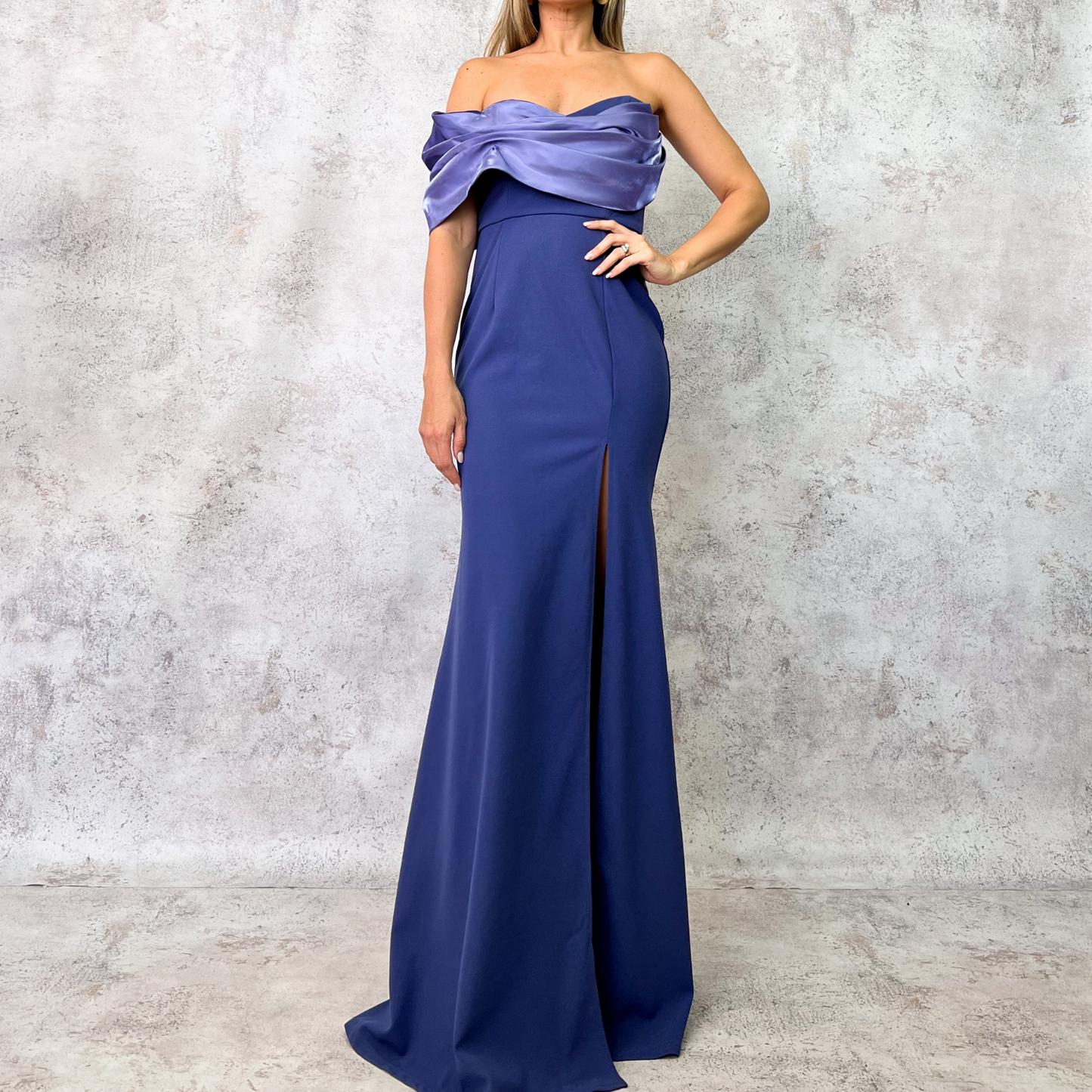 Vestido largo azul con escote drapeado y abertura.