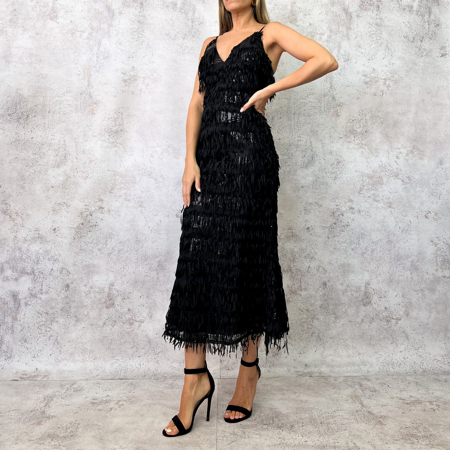 Vestido midi negro con flecos en capas.