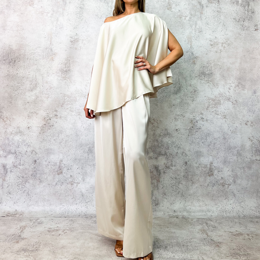 Conjunto beige con cinturón metálico.